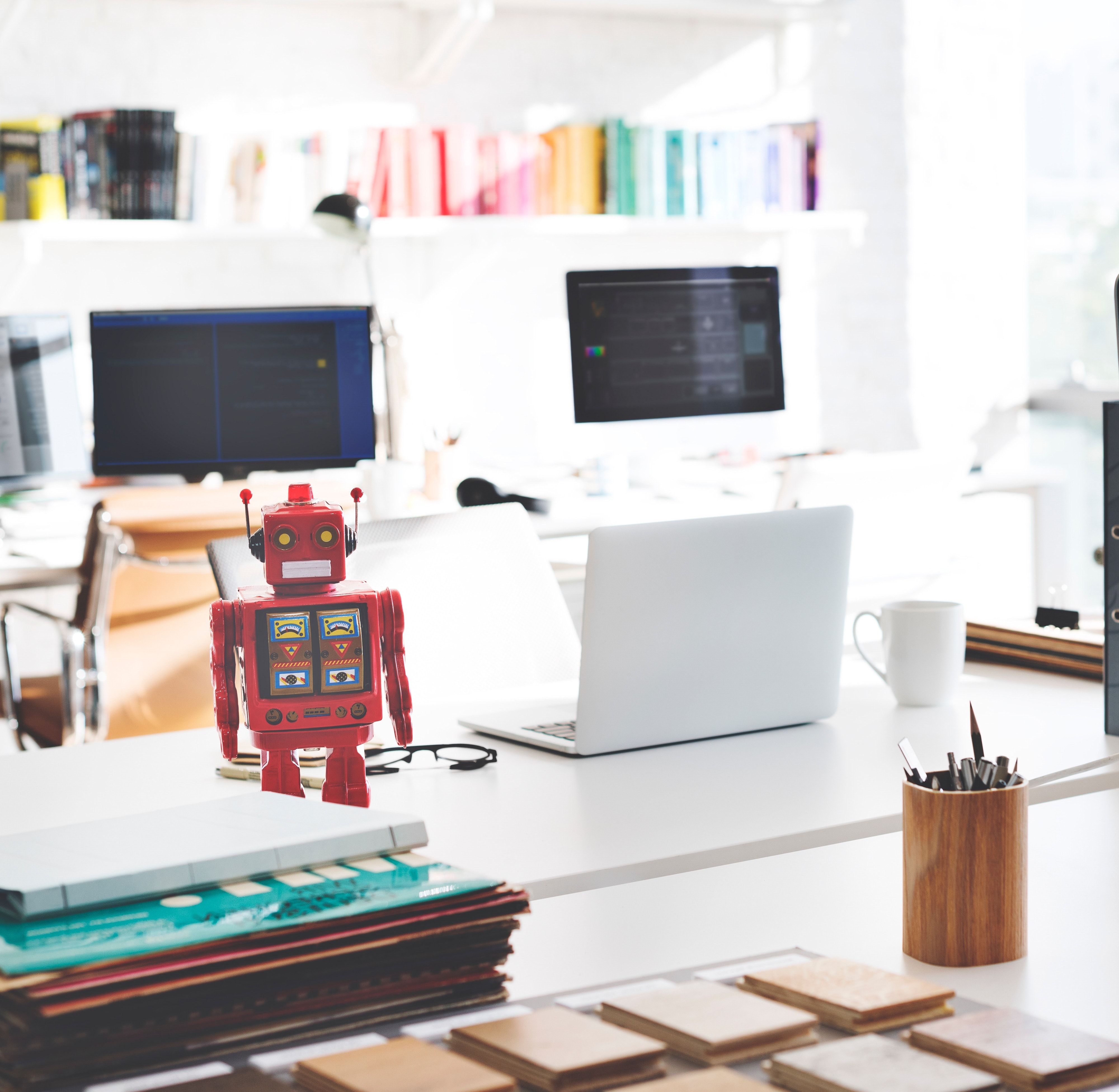 A chatbot robot on a desk with computers